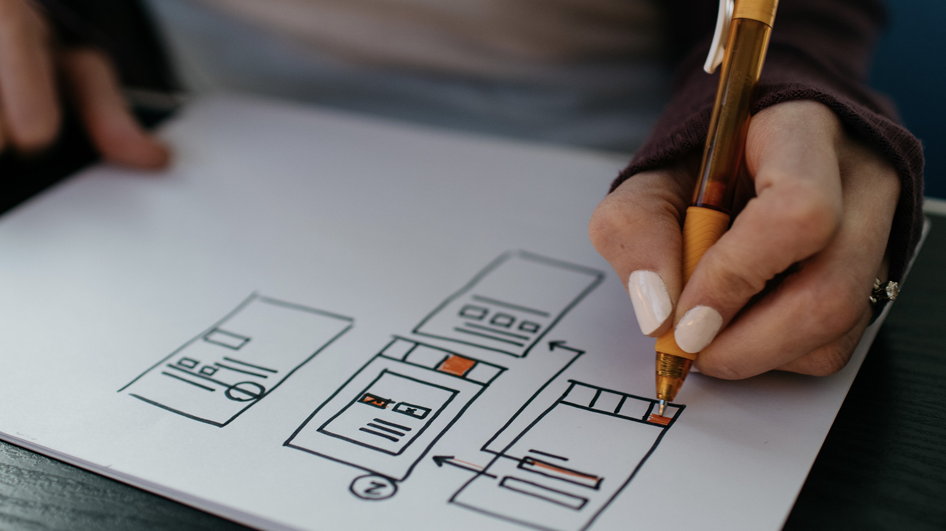 ux designer creating a wireframe for a houston web design company wearing white nailpolish